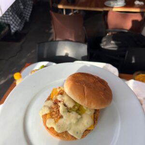 Burger de poisson croustillant au cheddar : filet pané, sauce tartare, servi sur un pain frais à Dakar